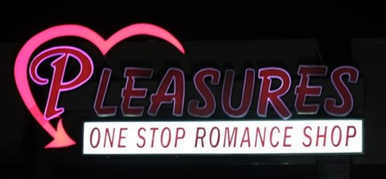 The Pleasures sign flickers over the old bank building in Huntsville, Ala. The "romance" store features what's billed as the nation's first drive-thru with adult novelties for sale. 